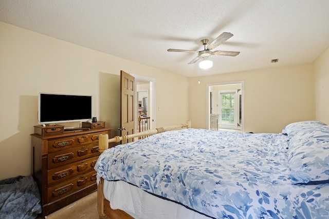 bedroom with a textured ceiling, dark colored carpet, and ceiling fan