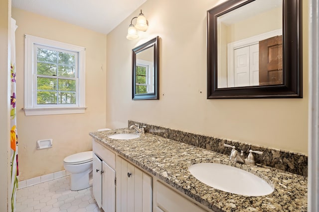 bathroom featuring double sink, tile floors, large vanity, and toilet