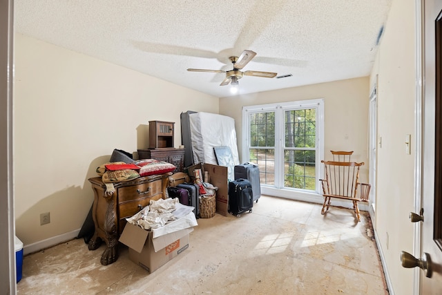 interior space with ceiling fan and a textured ceiling