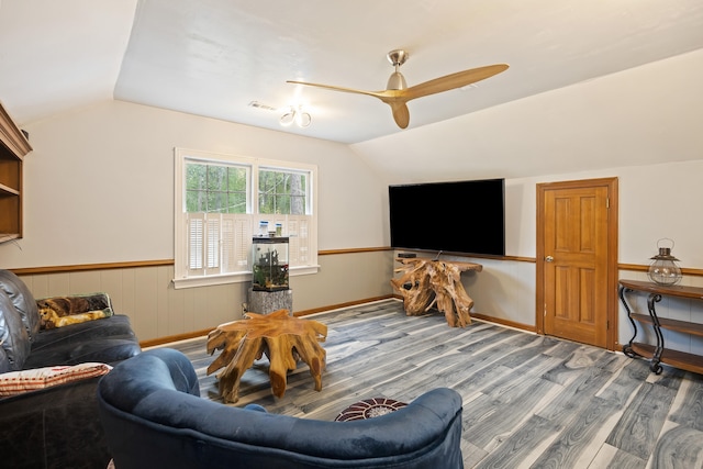 living room with ceiling fan, hardwood / wood-style floors, and vaulted ceiling