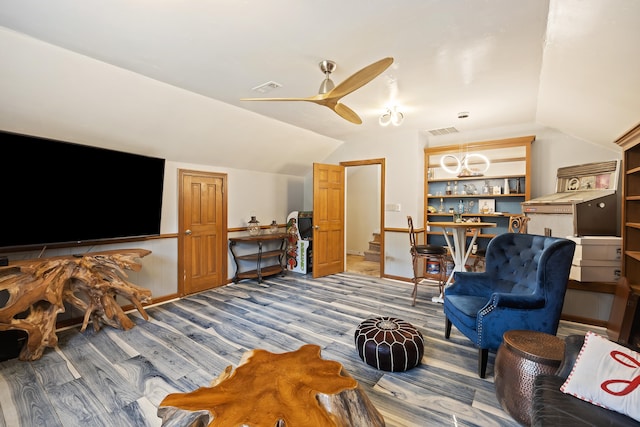 living room featuring dark hardwood / wood-style flooring, ceiling fan, and vaulted ceiling