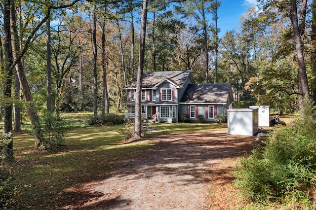 view of front of house with a front lawn and a storage unit