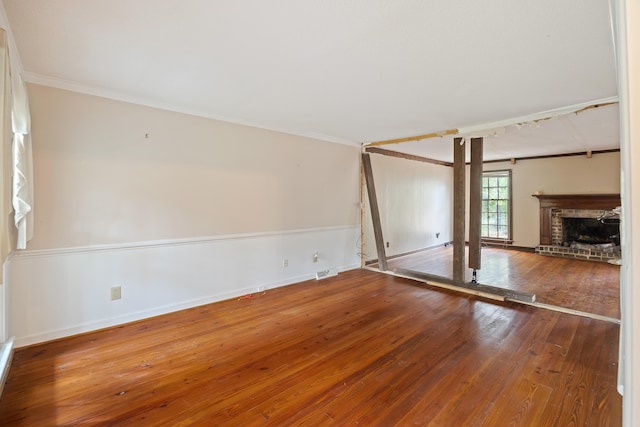 unfurnished living room with crown molding, dark hardwood / wood-style floors, and a fireplace