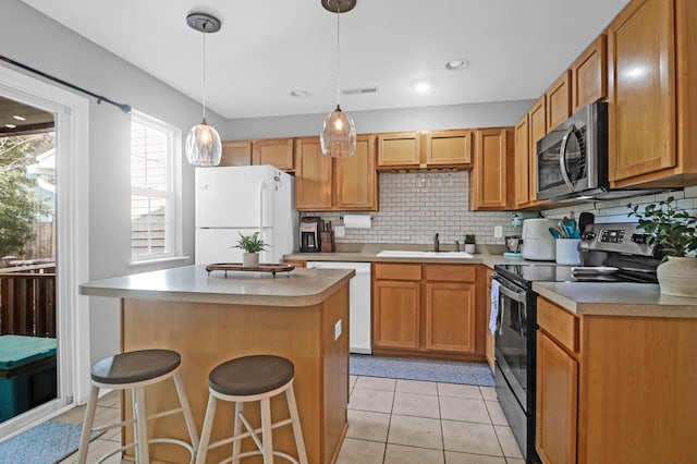 kitchen with stainless steel appliances, a kitchen breakfast bar, backsplash, pendant lighting, and a kitchen island