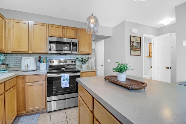 kitchen with pendant lighting, light brown cabinets, backsplash, light tile patterned floors, and stainless steel appliances