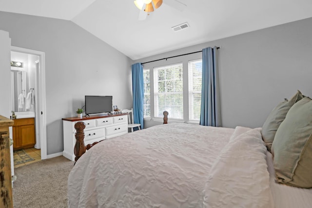 carpeted bedroom featuring ensuite bathroom, vaulted ceiling, and ceiling fan