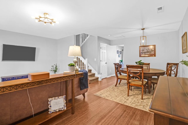 dining room with hardwood / wood-style floors and a notable chandelier