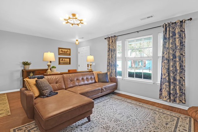 living room with hardwood / wood-style floors and an inviting chandelier