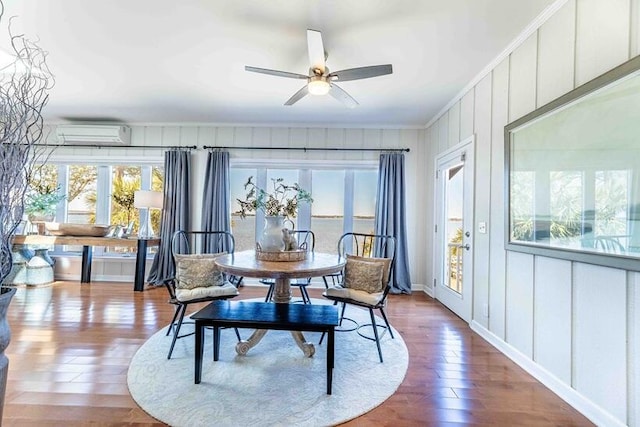 dining room with a wall mounted air conditioner, crown molding, a ceiling fan, and wood-type flooring
