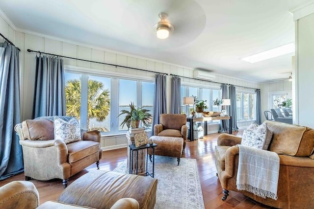 living room featuring ceiling fan, wood finished floors, an AC wall unit, and ornamental molding