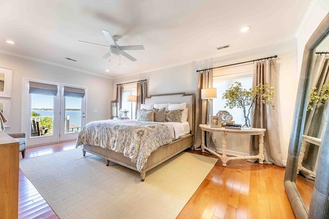 bedroom with visible vents, ornamental molding, light wood-type flooring, and access to outside