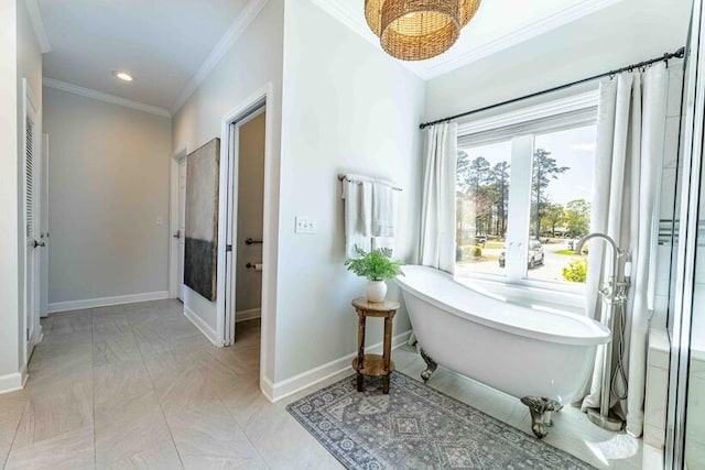 bathroom featuring baseboards, a freestanding tub, recessed lighting, and crown molding
