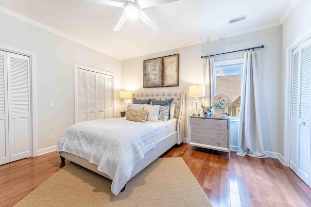 bedroom featuring visible vents, wood finished floors, and ornamental molding
