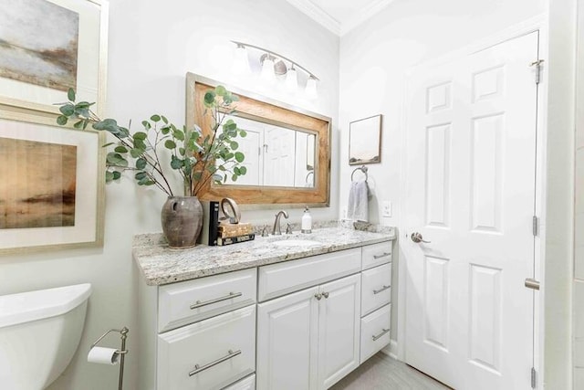 bathroom featuring ornamental molding, toilet, and vanity
