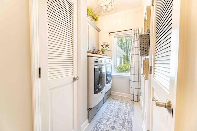 laundry area featuring crown molding, an inviting chandelier, cabinet space, separate washer and dryer, and light tile patterned floors