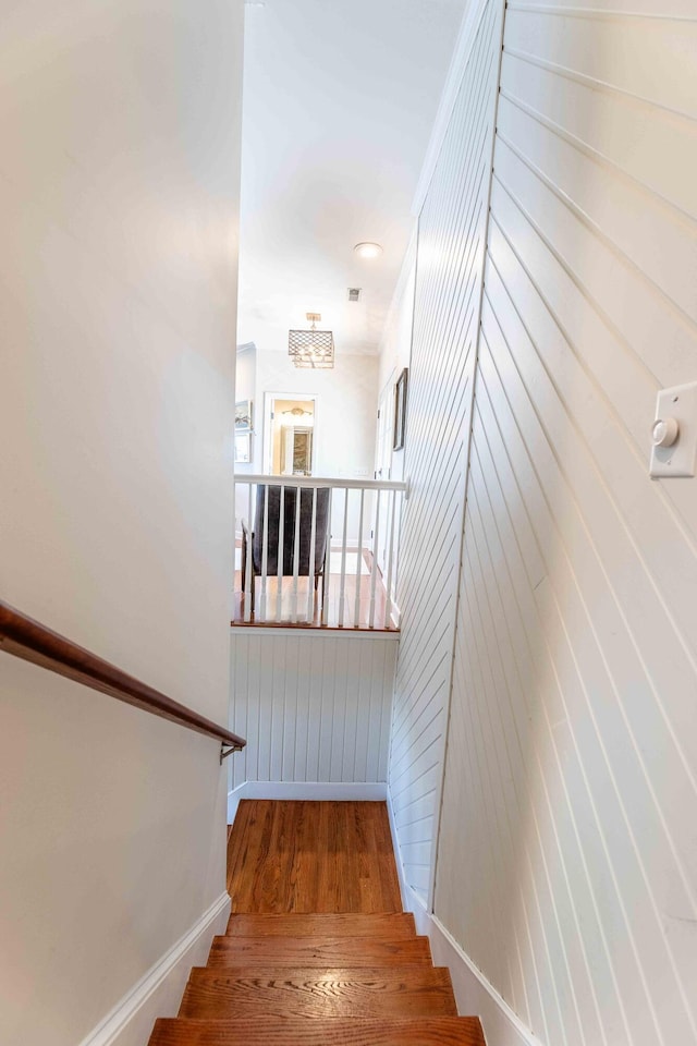 staircase featuring baseboards and wood finished floors