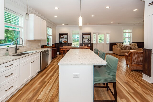 kitchen featuring dishwasher, a center island, light hardwood / wood-style floors, white cabinetry, and sink