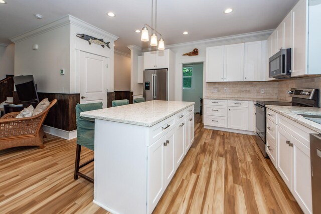 kitchen with white cabinets, stainless steel appliances, and light stone countertops