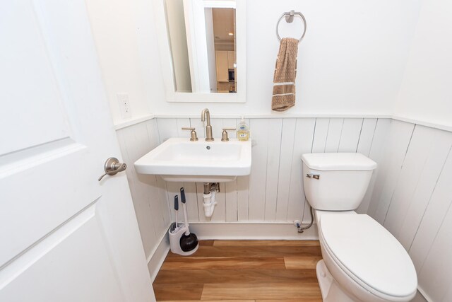 bathroom with toilet, hardwood / wood-style flooring, and sink