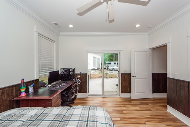 office space featuring light wood-type flooring, wood walls, ceiling fan, and ornamental molding