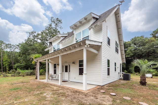 rear view of property with central air condition unit, a yard, a patio area, and a pergola