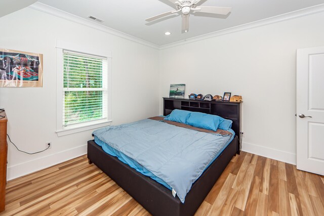 bedroom with ceiling fan, light hardwood / wood-style floors, and ornamental molding