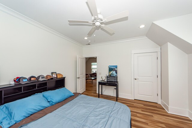 bedroom featuring crown molding, wood-type flooring, and ceiling fan