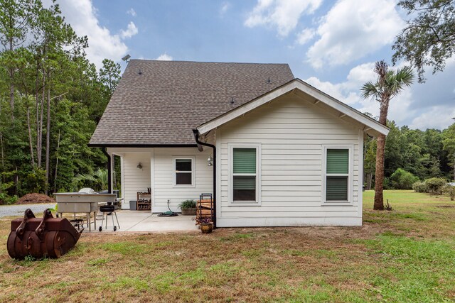 back of property with a lawn and a patio area