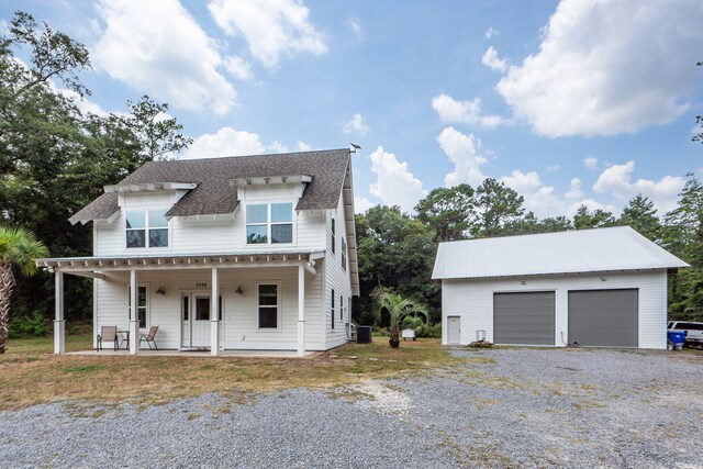 view of front of house featuring central AC, an outbuilding, covered porch, and a garage