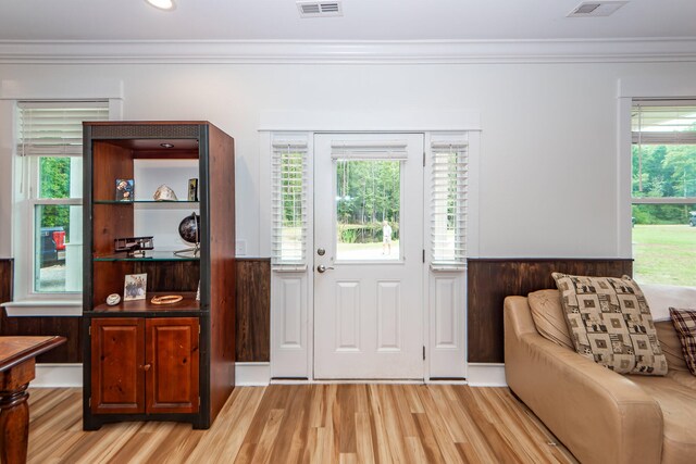 entrance foyer with ornamental molding and light hardwood / wood-style floors