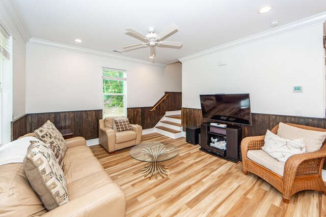 living room featuring ceiling fan, light hardwood / wood-style floors, and ornamental molding