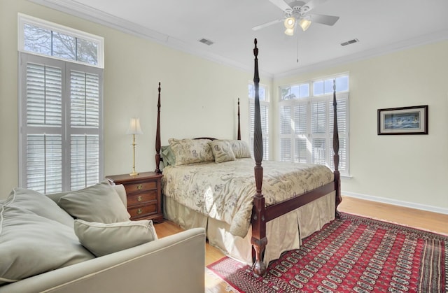 bedroom with light wood-style flooring, visible vents, and crown molding