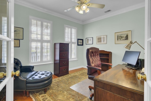 office space with wood finished floors, visible vents, baseboards, a ceiling fan, and ornamental molding