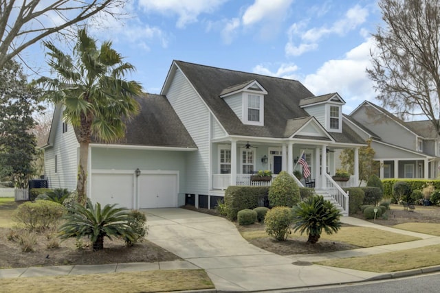 cape cod house with a porch, driveway, a shingled roof, and an attached garage