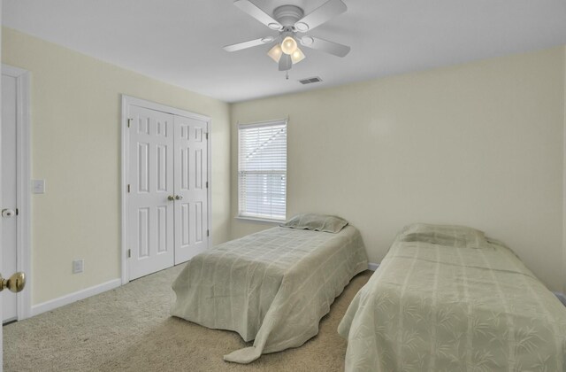 carpeted bedroom with a closet, visible vents, ceiling fan, and baseboards