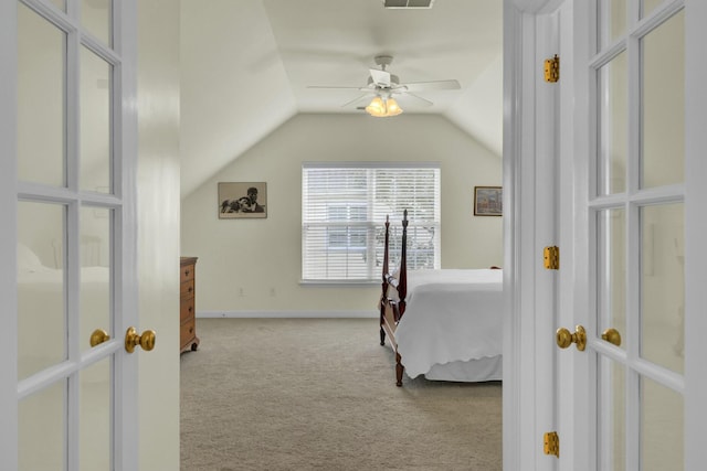 carpeted bedroom featuring lofted ceiling, ceiling fan, visible vents, and baseboards