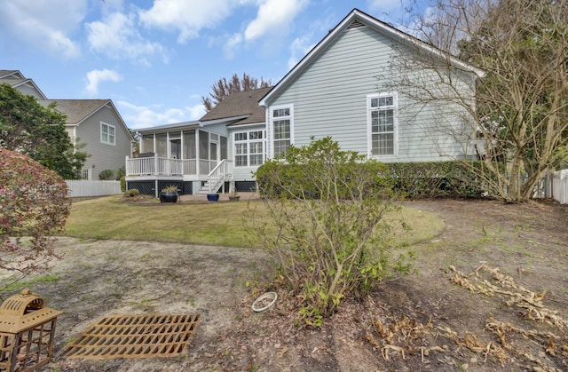 back of house featuring a sunroom, a yard, and fence