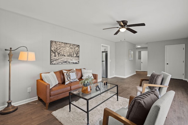 living room featuring ceiling fan and dark wood-type flooring