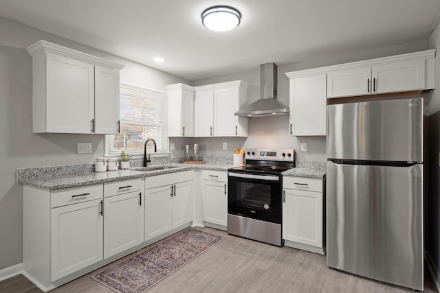 kitchen with wall chimney exhaust hood, sink, white cabinetry, and stainless steel appliances