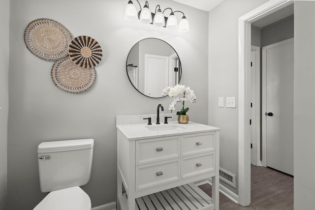 bathroom with vanity, wood-type flooring, and toilet