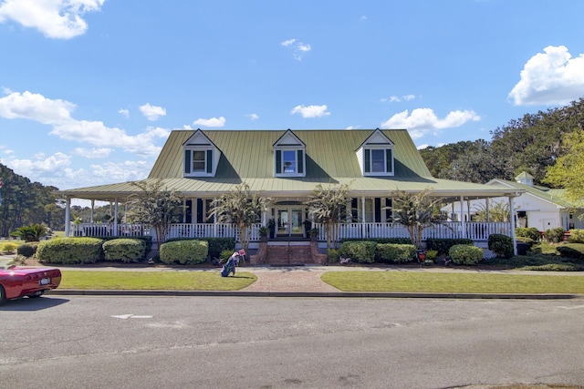 farmhouse featuring a porch and metal roof