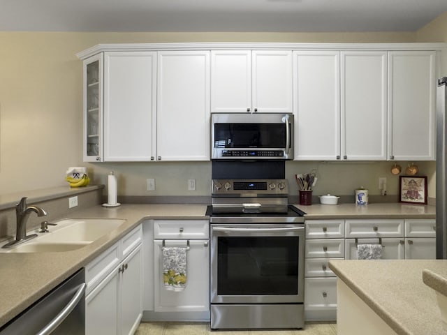 kitchen with white cabinetry, appliances with stainless steel finishes, light countertops, and a sink