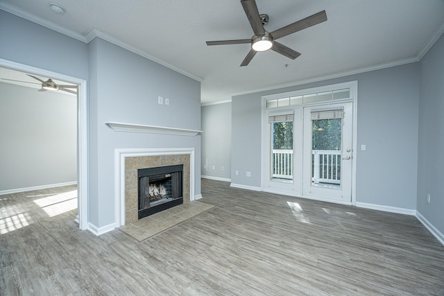 unfurnished living room with hardwood / wood-style flooring, a tile fireplace, and ceiling fan