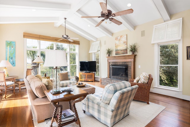 living room with hardwood / wood-style floors, lofted ceiling with beams, a brick fireplace, and ceiling fan