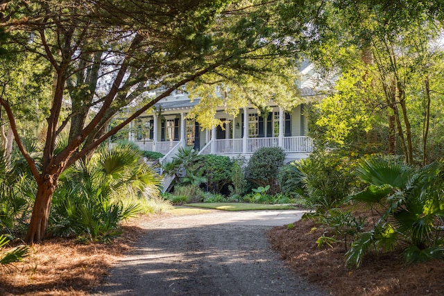 view of property hidden behind natural elements with a porch