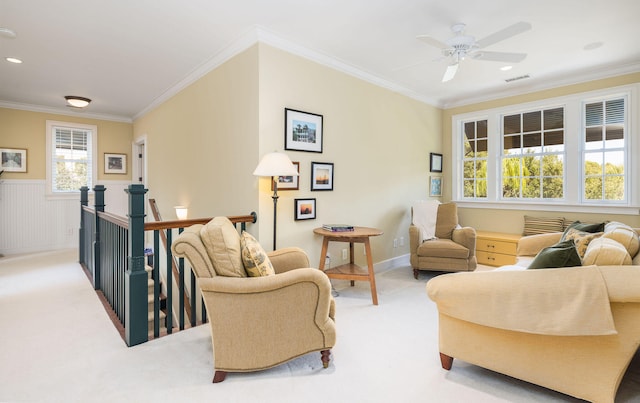 carpeted living room with crown molding and ceiling fan