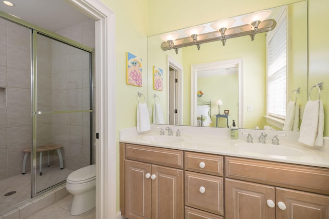 bathroom with toilet, vanity, tile patterned floors, and a shower with door