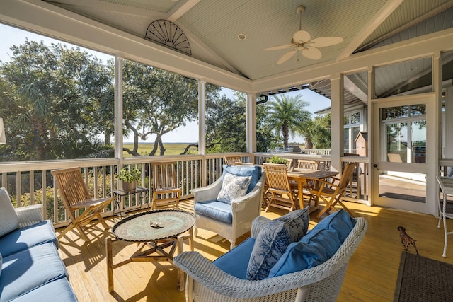 sunroom / solarium featuring lofted ceiling with beams, plenty of natural light, and ceiling fan