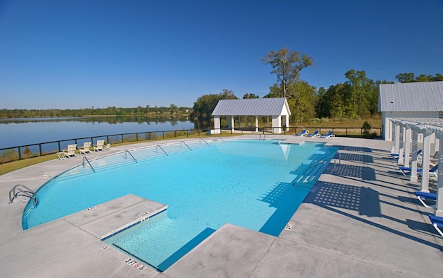 view of swimming pool featuring a water view and a patio