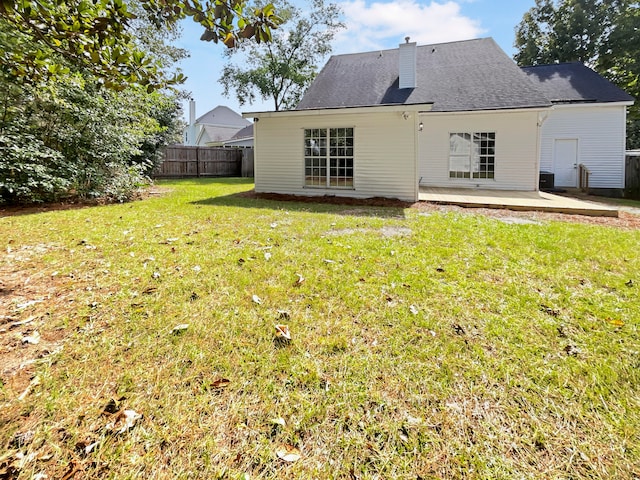 back of property featuring a lawn and a patio